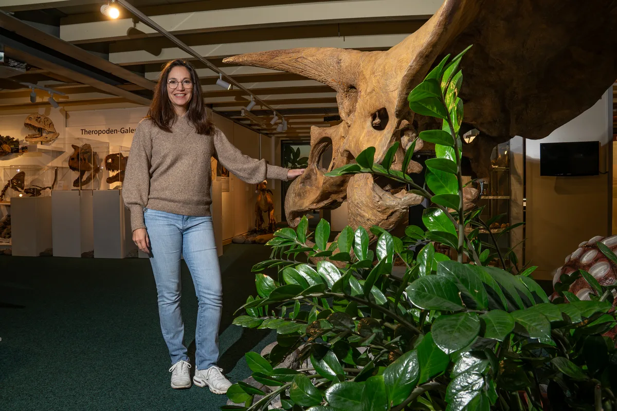 Yolanda Schicker-Siber posiert vor einem Saurierkopf.